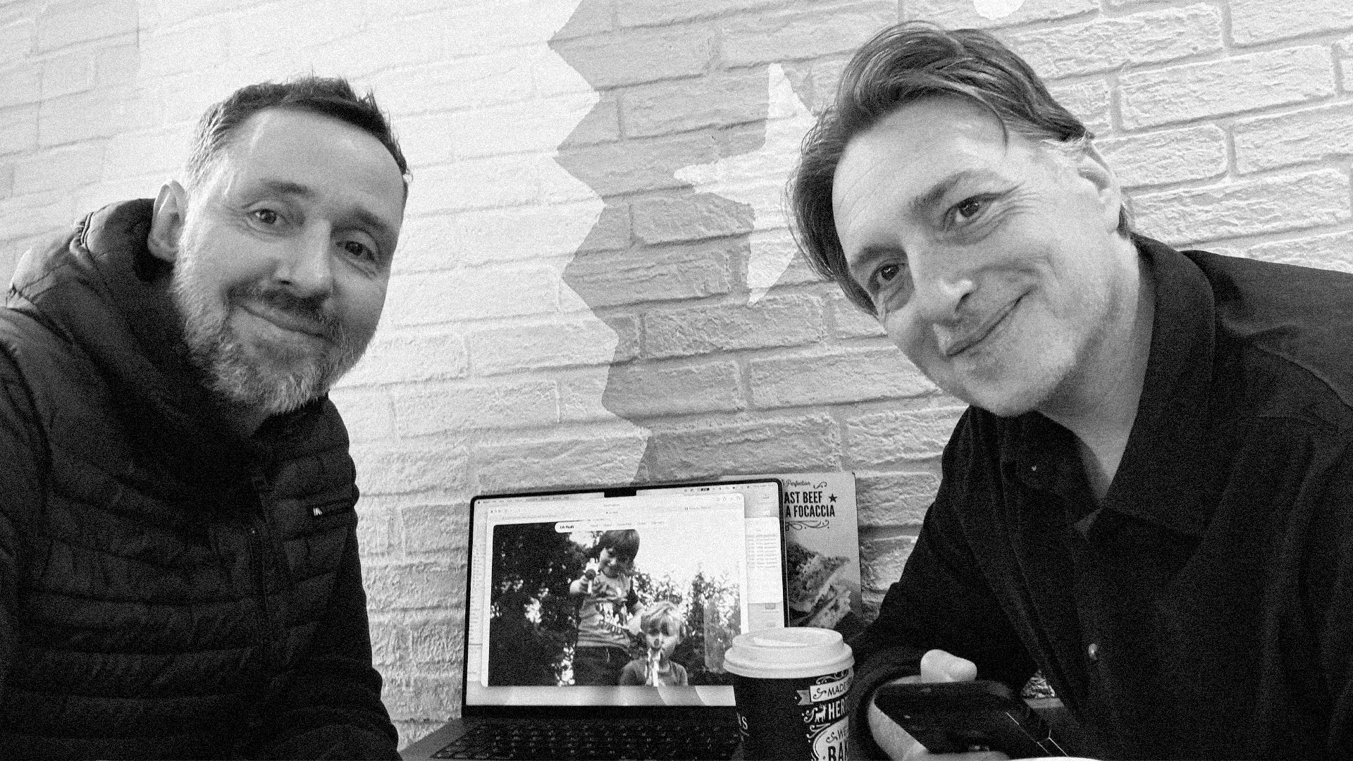 Paul and Jon together, holding a childhood photograph.