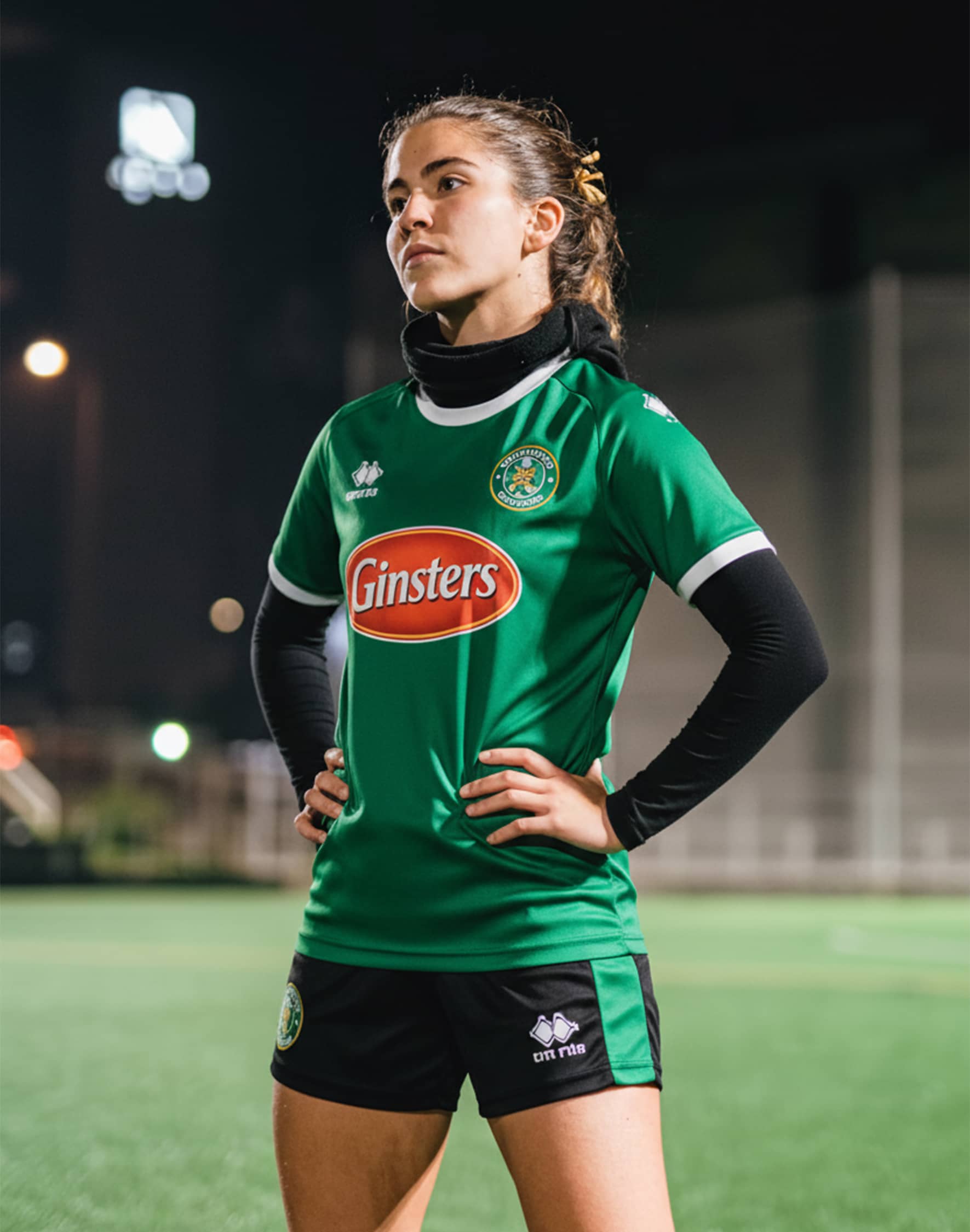 A female rugby player wearing a green kit.