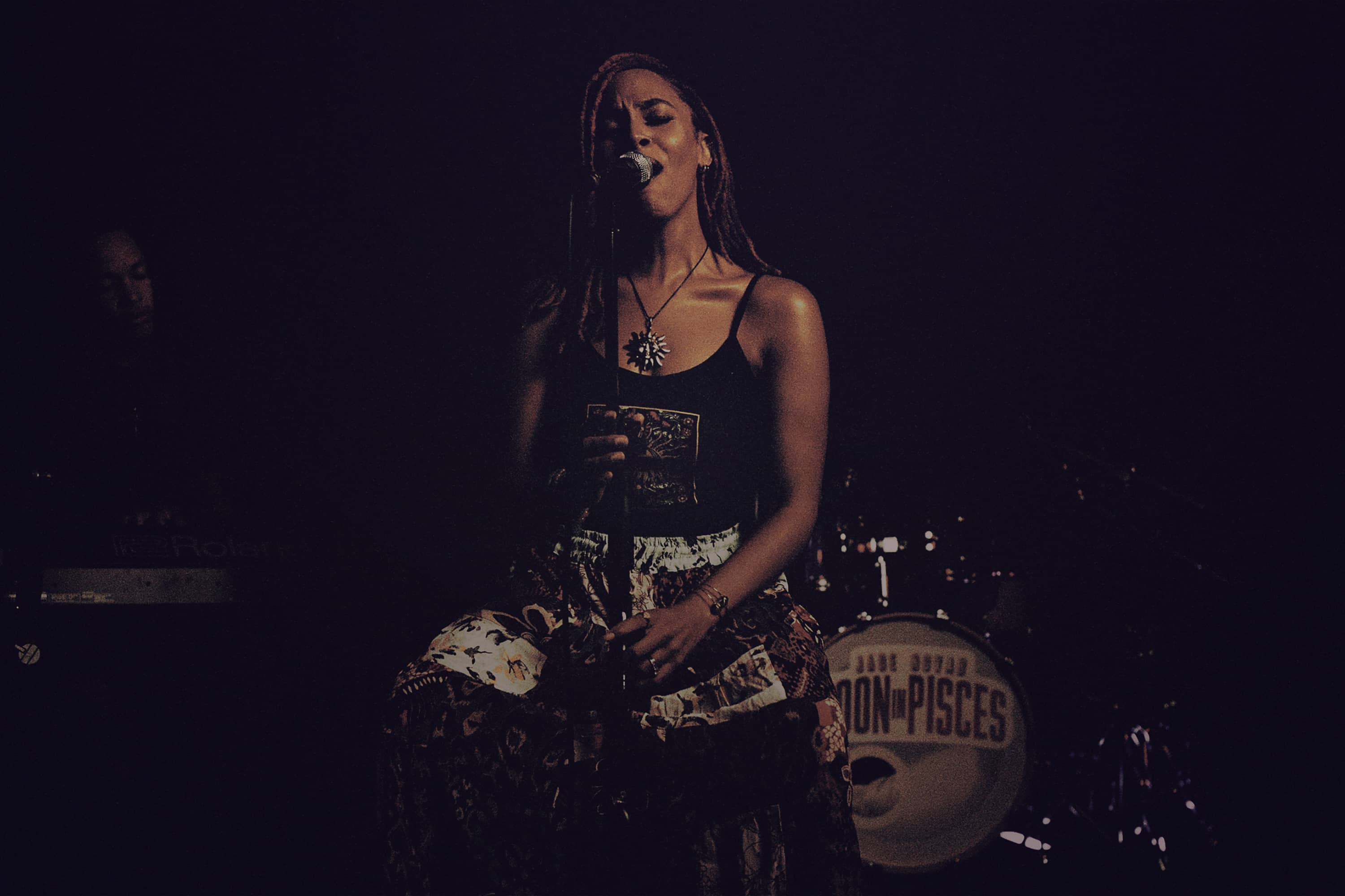 A singer performing on a dark stage.