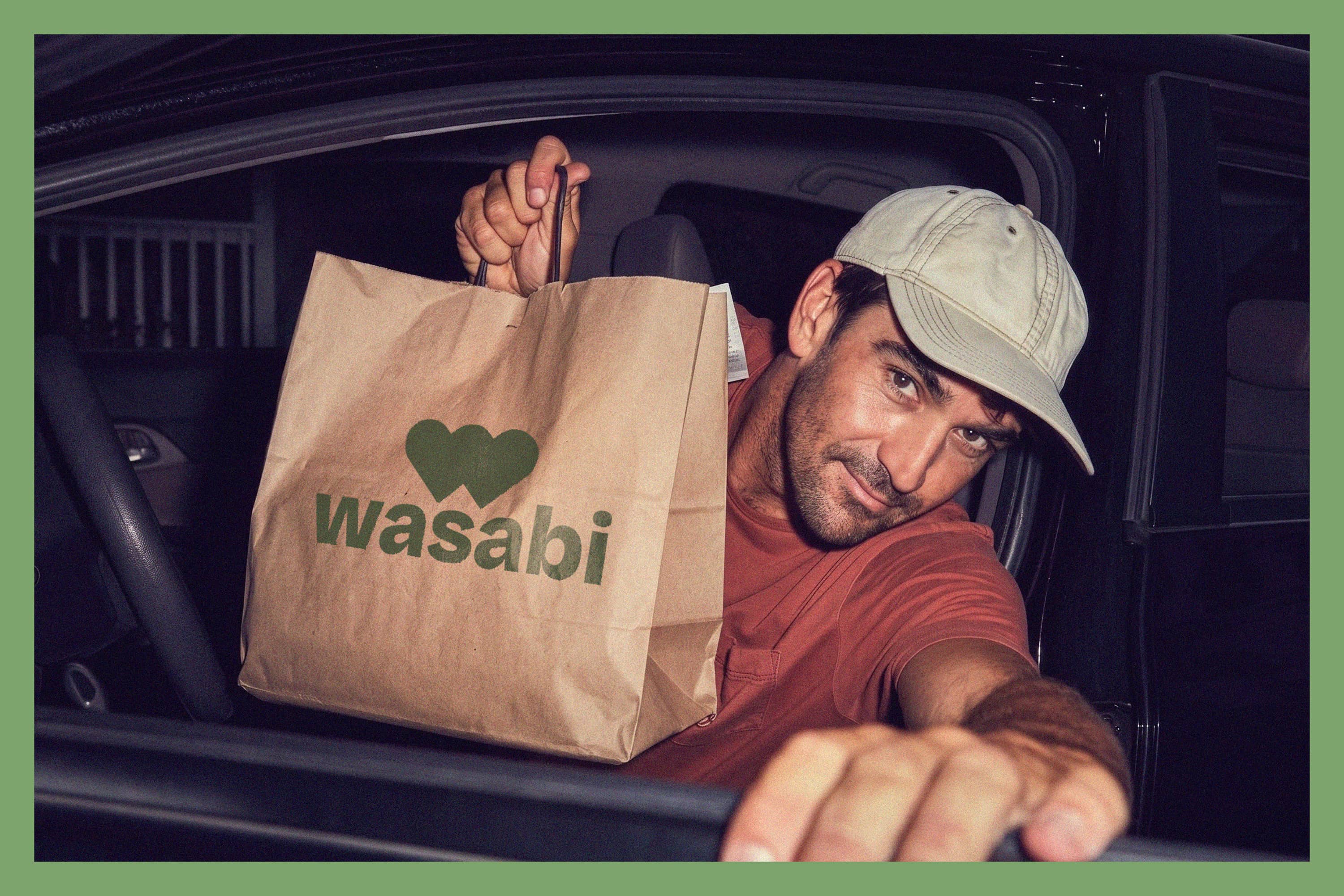 Wasabi takeaway campaign featuring a smiling driver holding a branded paper bag.