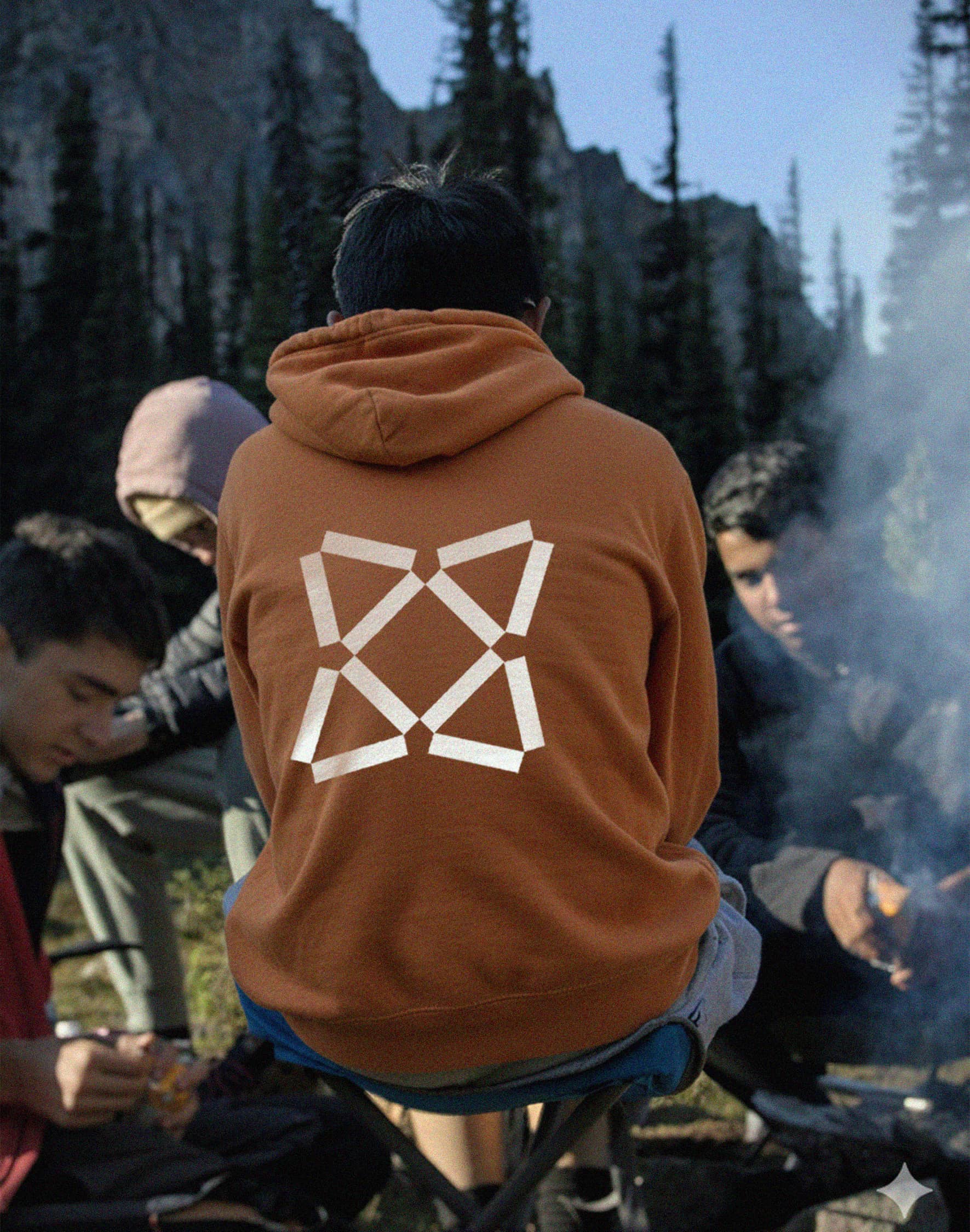 A brown hoodie with the white Wolf Pack emblem, worn outdoors beside a stream.